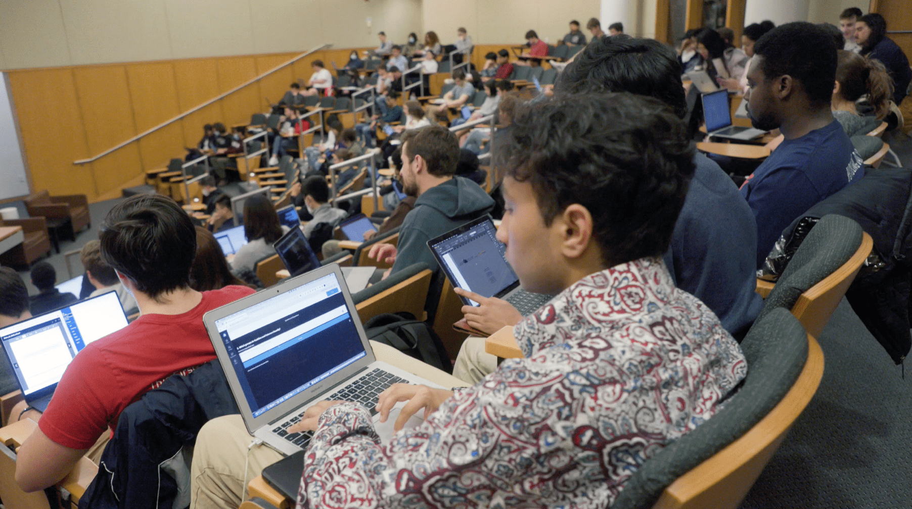 students typing on laptops during class