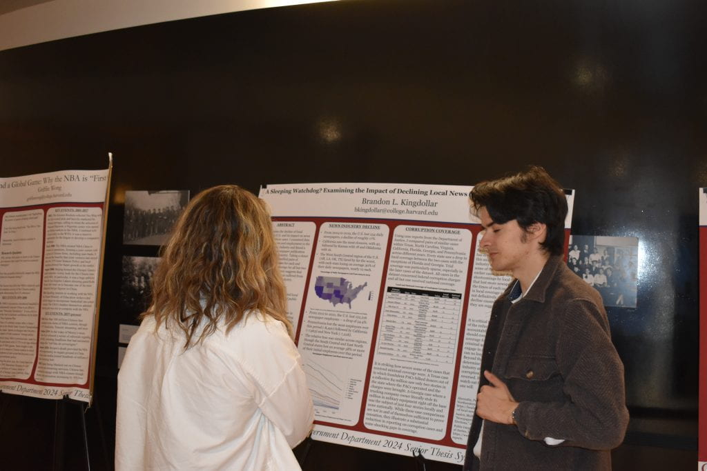Two people discussing in front of a presentation board